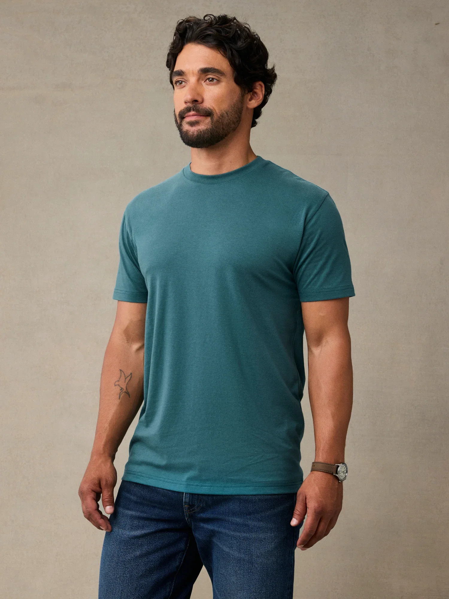 Man wearing a teal blue crew neck t-shirt in StratuSoft cotton poly blend